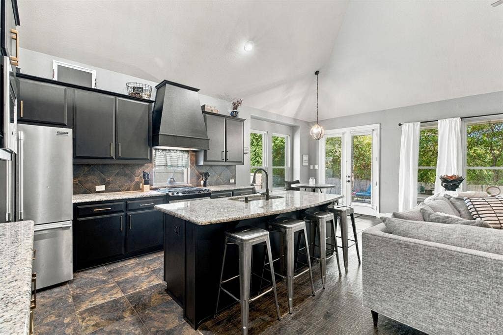 Brand new rich dark cabinetry, granite countertops, stainless steel appliances, a decorative tile backsplash, and generous island seating combine style with everyday functionality.