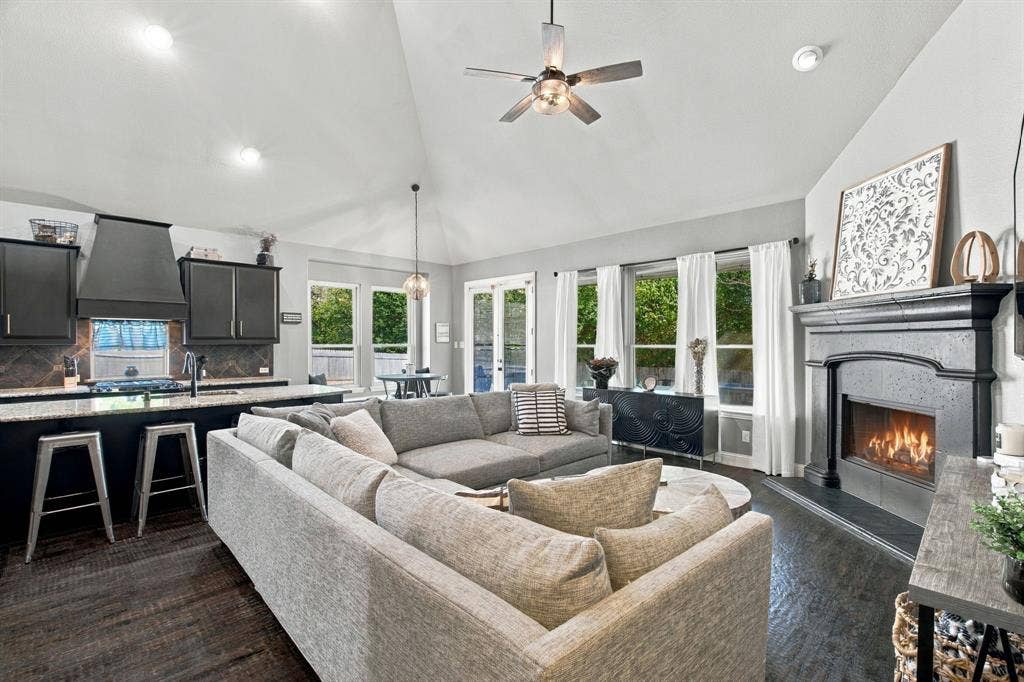 Large windows overlooking the backyard fill this inviting space with natural light, while the fireplace and open connection to the kitchen make it ideal for everyday living and entertaining.