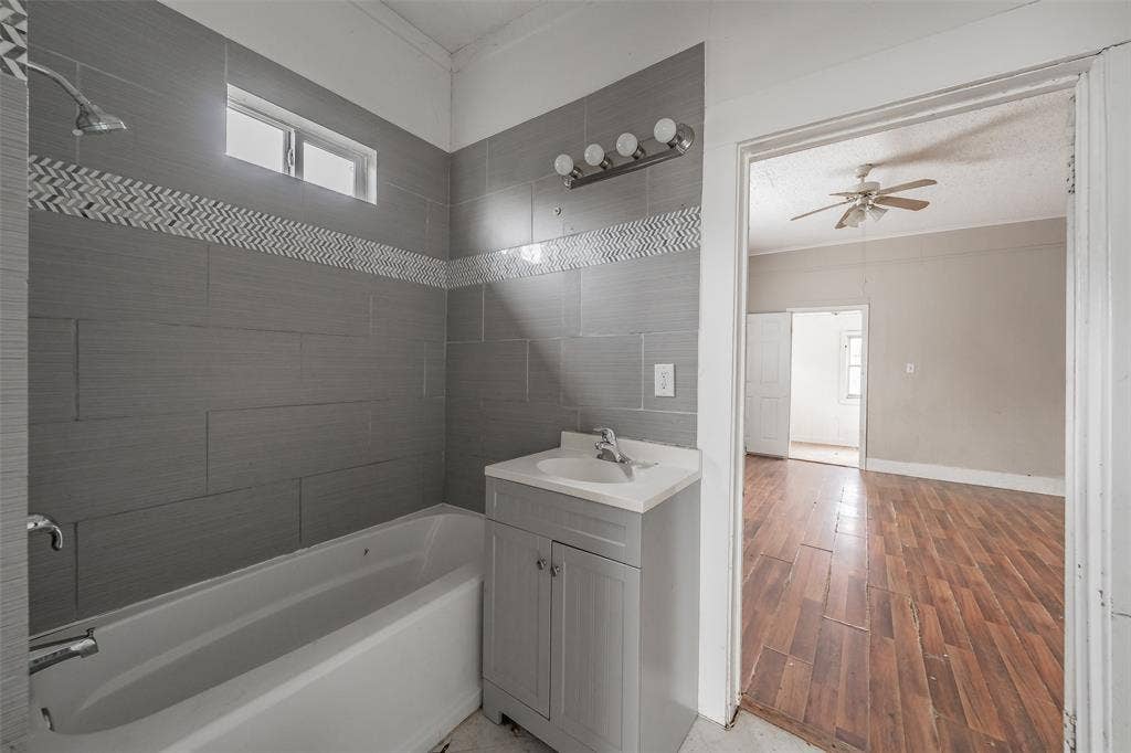 212 N Ruddell Street, Denton, TX 76205 Gray tiled shower surround with a decorative mosaic border