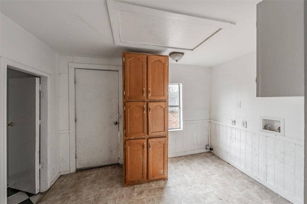 212 N Ruddell Street, Denton, TX 76205 Wood-finish cabinetry, beadboard wainscoting, and a single window