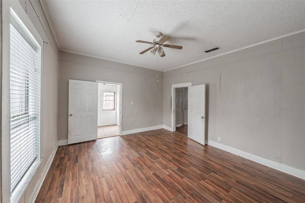 212 N Ruddell Street, Denton, TX 76205 Wood-finish flooring, multiple paneled doors, window with blinds, and a ceiling fan