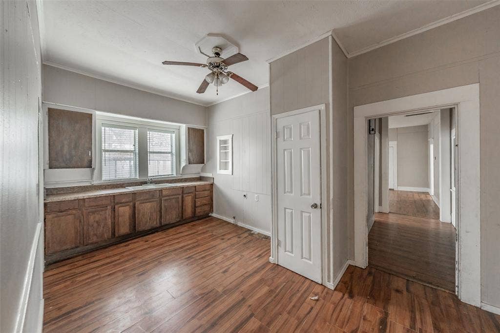 212 N Ruddell Street, Denton, TX 76205 Wood-finish flooring, built-in cabinetry, two windows with blinds, ceiling fan with light fixture, and a paneled interior door