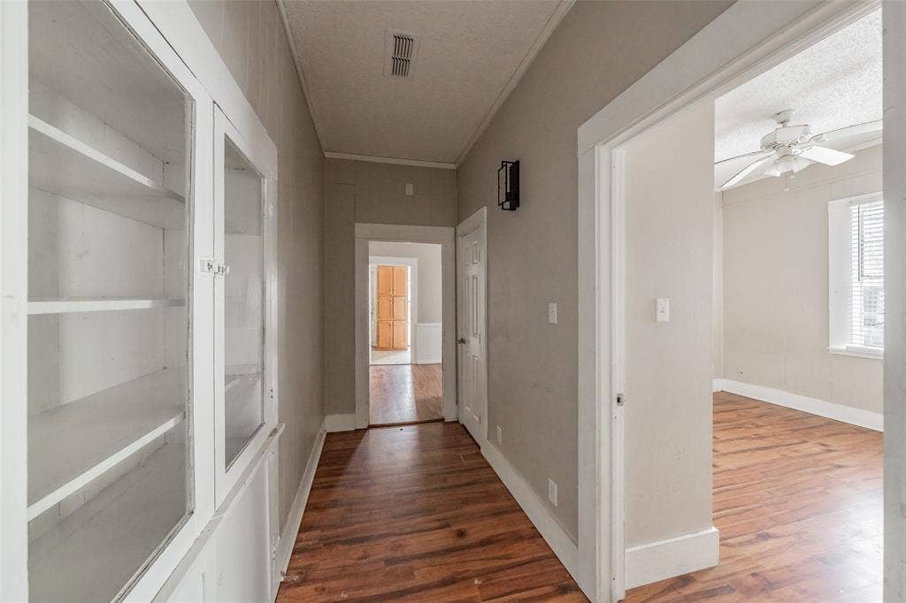 212 N Ruddell Street, Denton, TX 76205 Wood-finish flooring throughout, built-in display cabinet with glass doors, and a ceiling fan with light kit