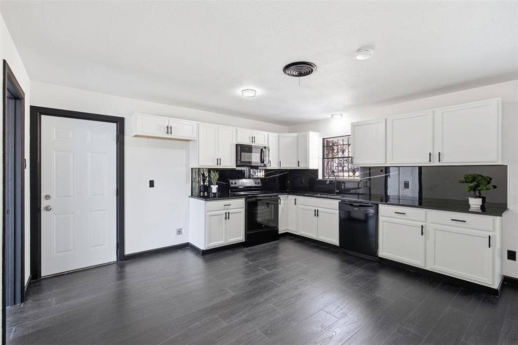 2313 Clearview Drive, Fort Worth, TX 76119 Kitchen featuring white cabinetry, dark countertops, dark backsplash, a built-in dishwasher, and wood-finish flooring