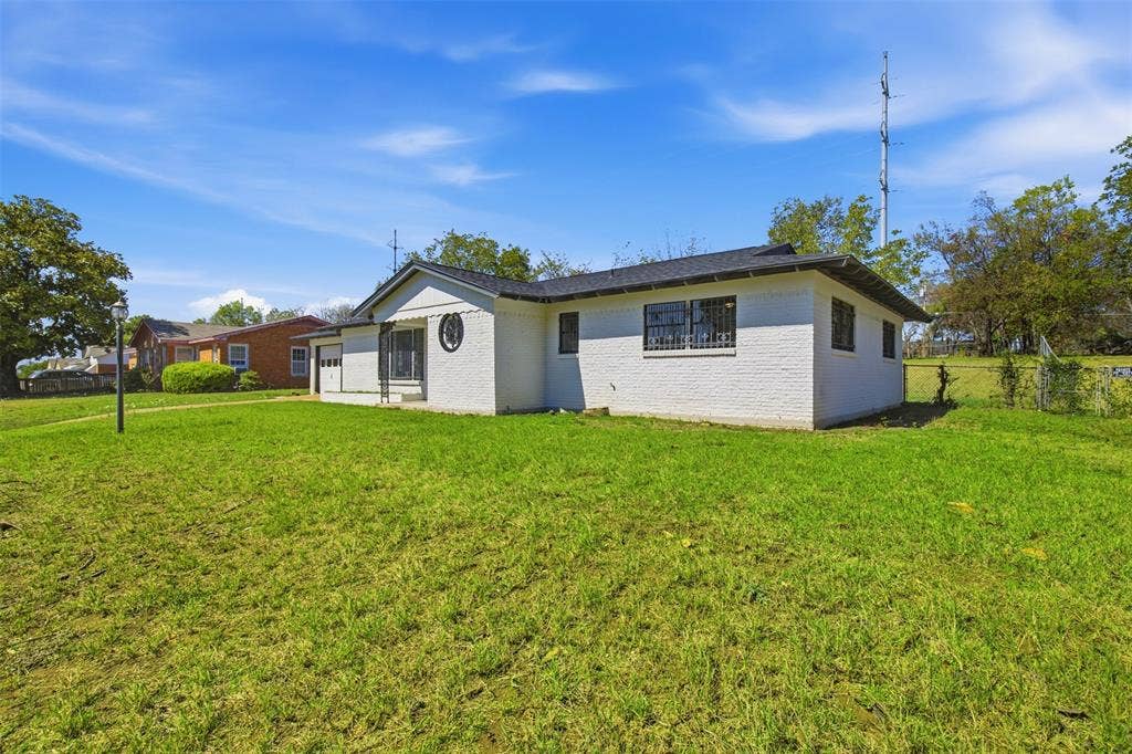 2313 Clearview Drive, Fort Worth, TX 76119 White painted brick exterior with a black shingle roof, offering a single-car garage and security bars on windows