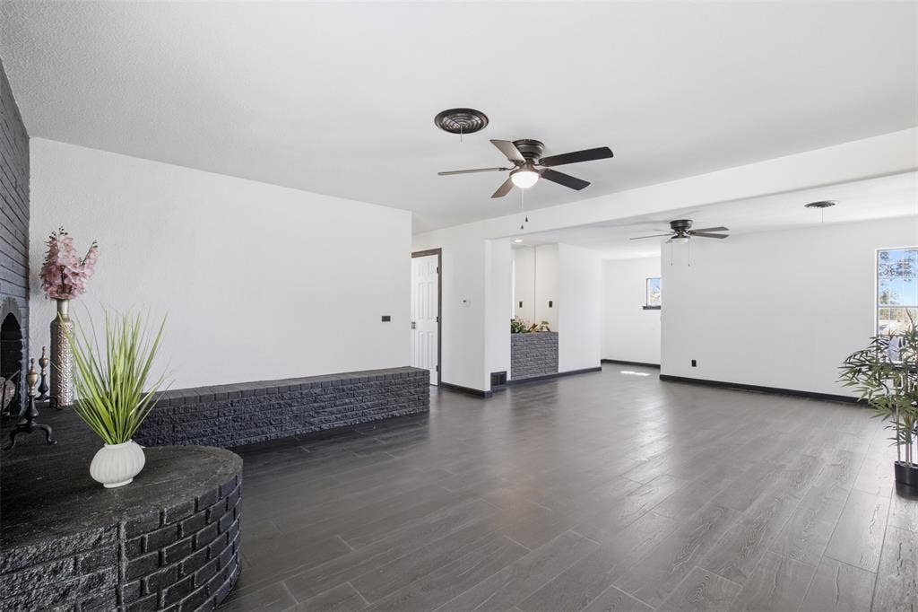 2313 Clearview Drive, Fort Worth, TX 76119 Expansive room featuring dark wood-finish flooring, white walls, and multiple ceiling fans