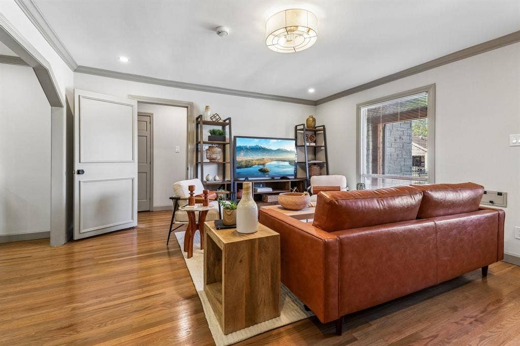 Hardwood flooring, recessed lighting, crown molding, paneled interior doors, and a decorative ceiling light fixture