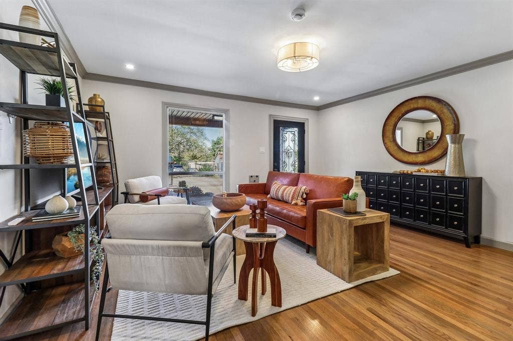 Hardwood flooring, recessed lighting, crown molding, a decorative front entry door, and a built-in shelving unit