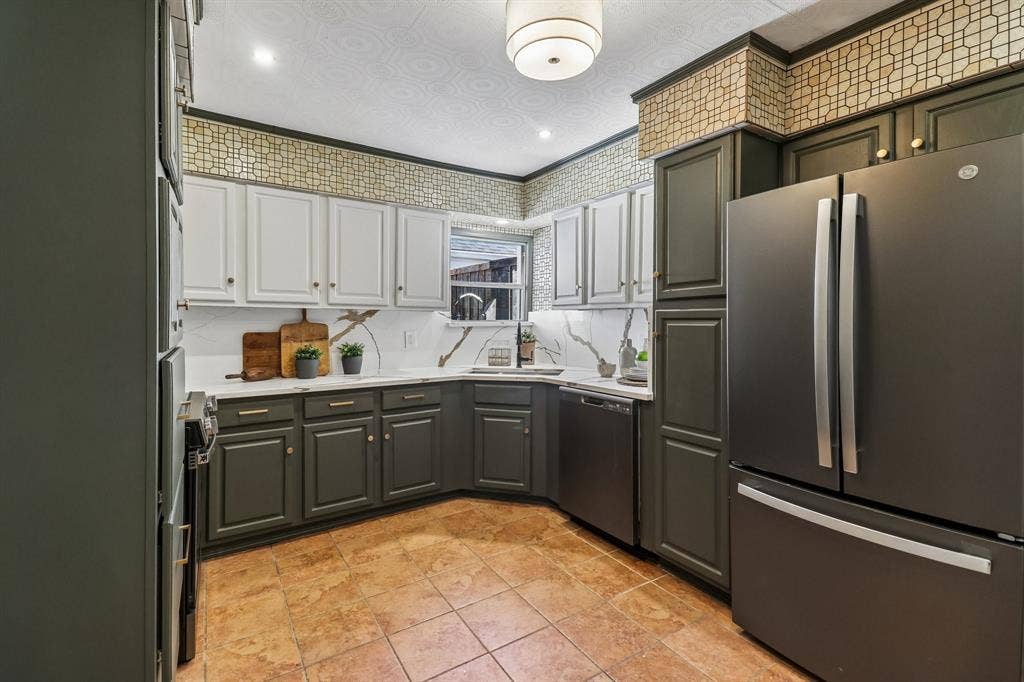 Matte finish appliances, two-tone cabinetry with gold-tone hardware, tile flooring, corner sink, and recessed lighting