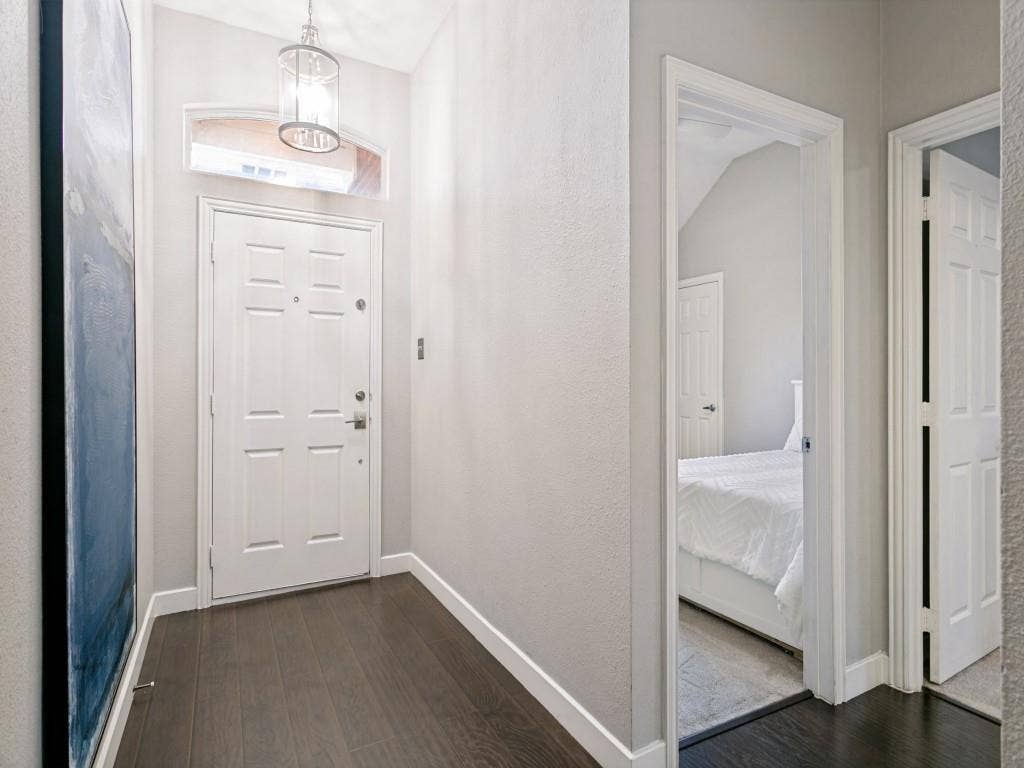 Entryway featuring wood-finish flooring, a white paneled door, and a transom window