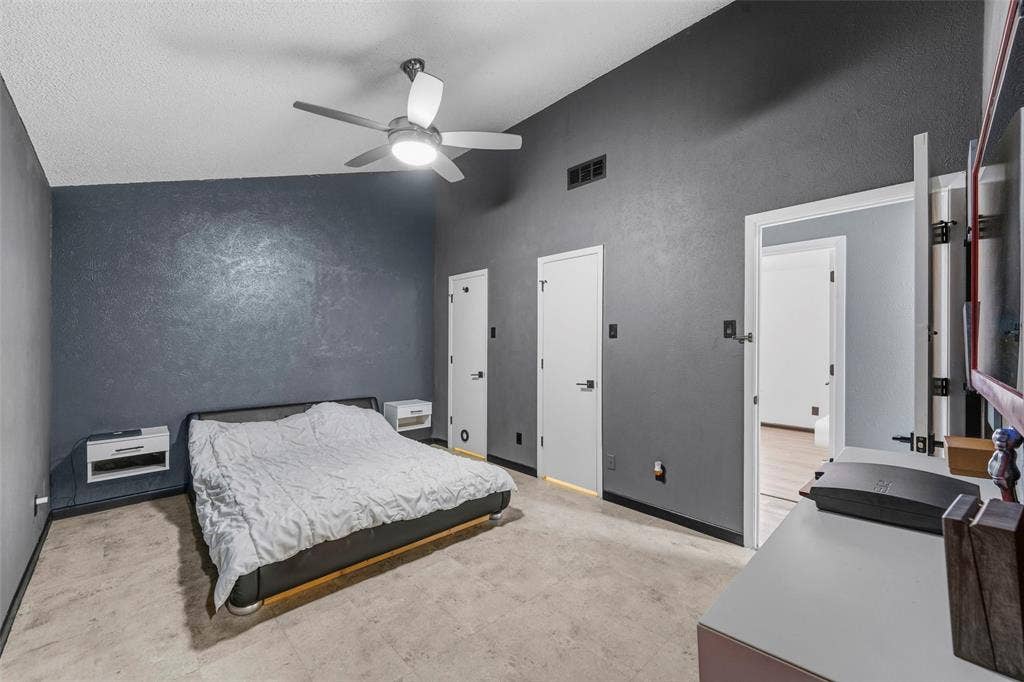 6606 Coleshire Drive, Dallas, TX 75232 Vaulted ceiling with a contemporary ceiling fan, modern wall sconces, wood-finish flooring, and white interior doors