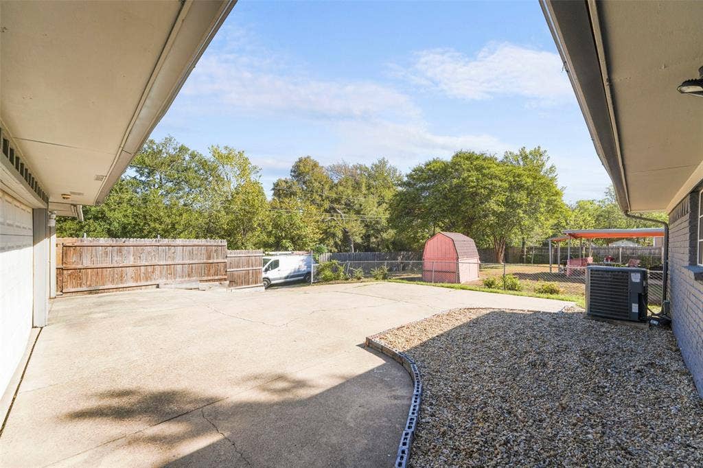 6606 Coleshire Drive, Dallas, TX 75232 Expansive concrete patio with gravel border and wood privacy fencing