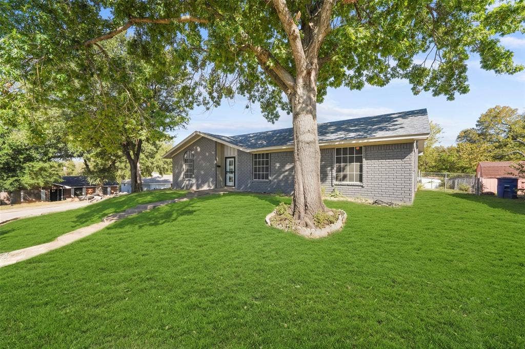 6606 Coleshire Drive, Dallas, TX 75232 Gray brick exterior, composition shingle roof, mature front yard tree, concrete walkway