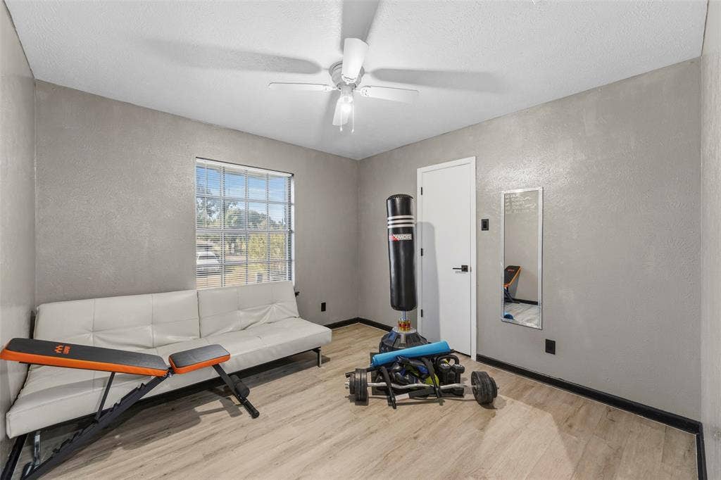 6606 Coleshire Drive, Dallas, TX 75232 Recessed window with grid panes, overhead ceiling fan with light, and wood-finish flooring