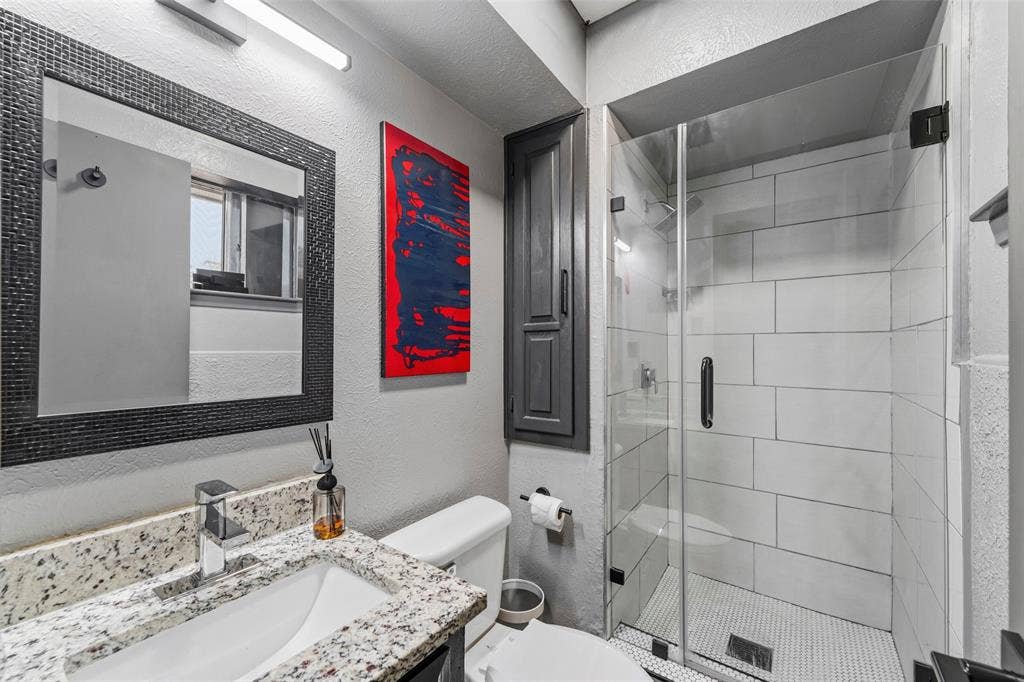 6606 Coleshire Drive, Dallas, TX 75232 Frameless glass shower enclosure with subway tile surround and mosaic floor
