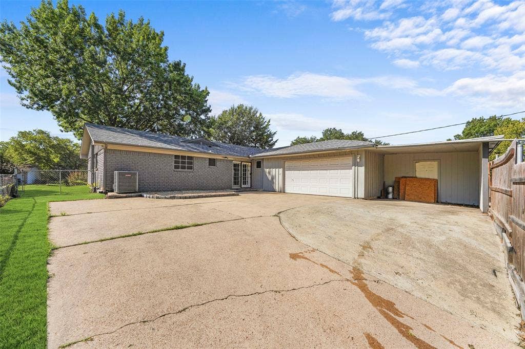 6606 Coleshire Drive, Dallas, TX 75232 Brick exterior with a gabled roofline, attached garage, covered carport, and concrete driveway