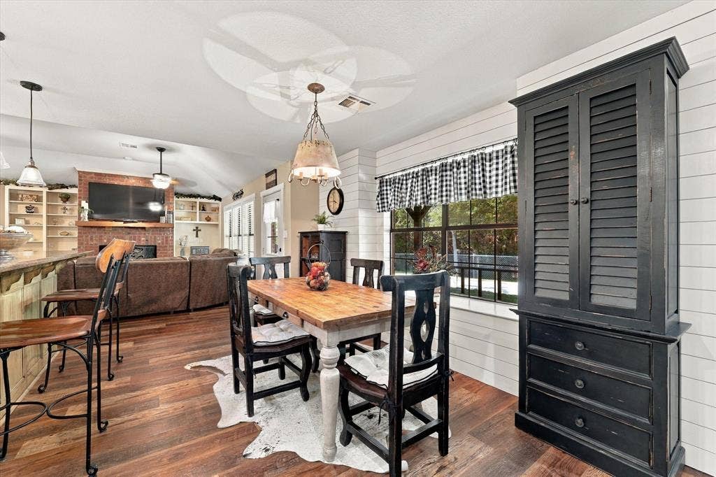 1600 Fox Ridge Road, Lorena, TX 76655 Wood-finish flooring, horizontal shiplap wall paneling, built-in floor-to-ceiling cabinetry with louvered doors, brick fireplace surround, and recessed ceiling lighting