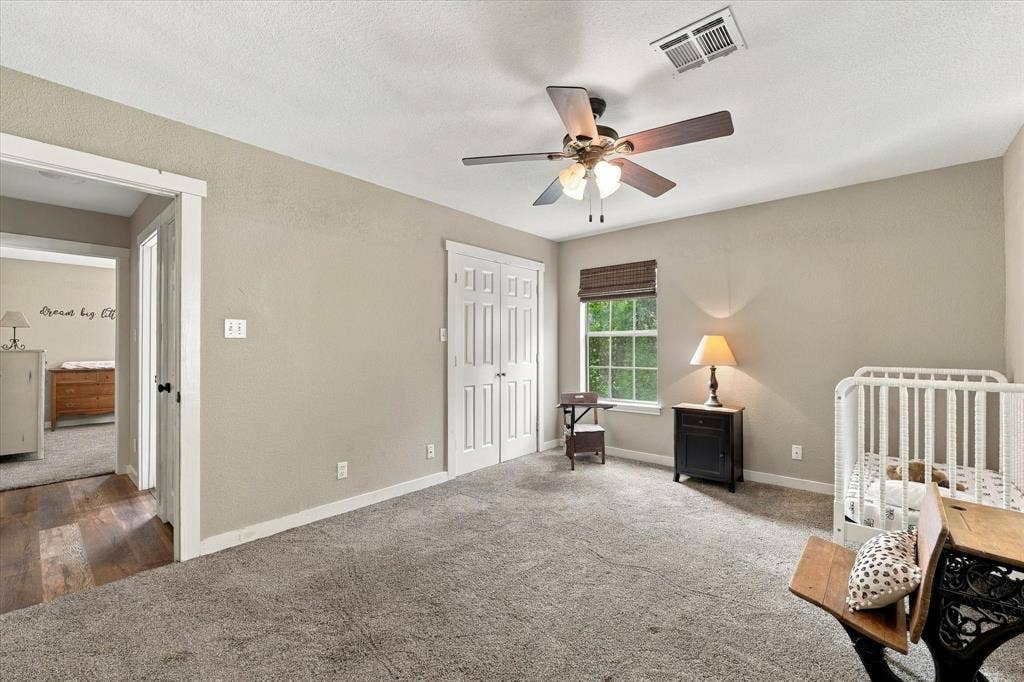 1600 Fox Ridge Road, Lorena, TX 76655 Neutral-toned interior featuring wall-to-wall carpeting, dual-door closet with white trim, ceiling fan with integrated lighting, and a window with a woven shade