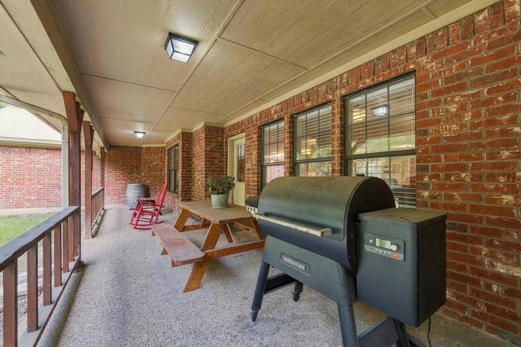 1600 Fox Ridge Road, Lorena, TX 76655 Covered patio featuring red brick exterior walls, aggregate flooring, and wooden structural supports