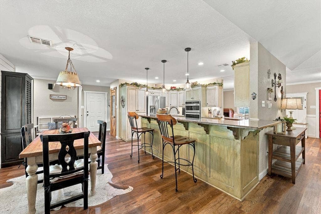 1600 Fox Ridge Road, Lorena, TX 76655 Kitchen featuring a spacious peninsula with an overhanging countertop, built-in wall oven, wood-finish flooring, recessed lighting, and decorative pendant fixtures