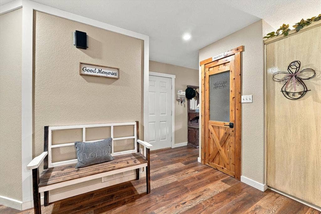 1600 Fox Ridge Road, Lorena, TX 76655 Interior space featuring wood-finish flooring, a wood-frame pantry door with a frosted glass panel, and a built-in closet with textured panel doors