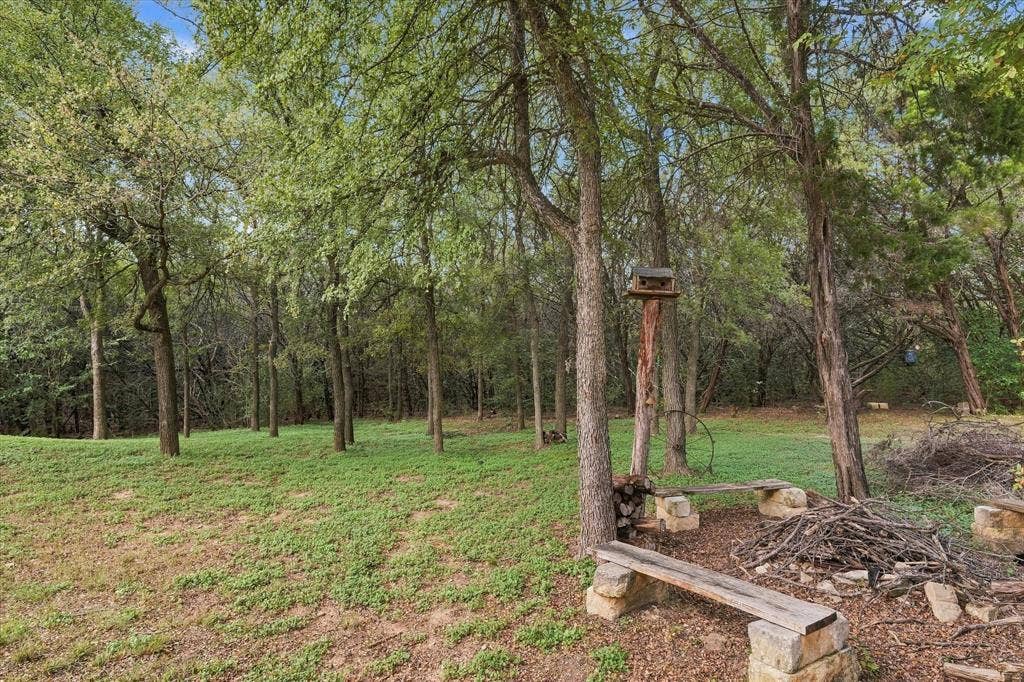 1600 Fox Ridge Road, Lorena, TX 76655 Wooded lot featuring mature trees, natural ground cover, and built-in stone and timber benches