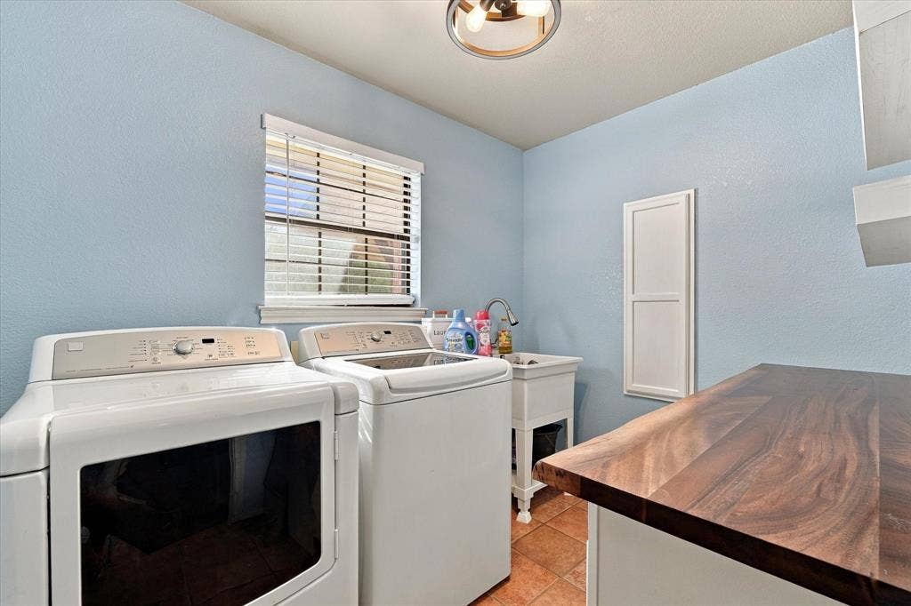 1600 Fox Ridge Road, Lorena, TX 76655 Laundry space featuring a wooden countertop, utility sink with a gooseneck faucet, window with horizontal blinds, and a circular flush-mount ceiling light fixture