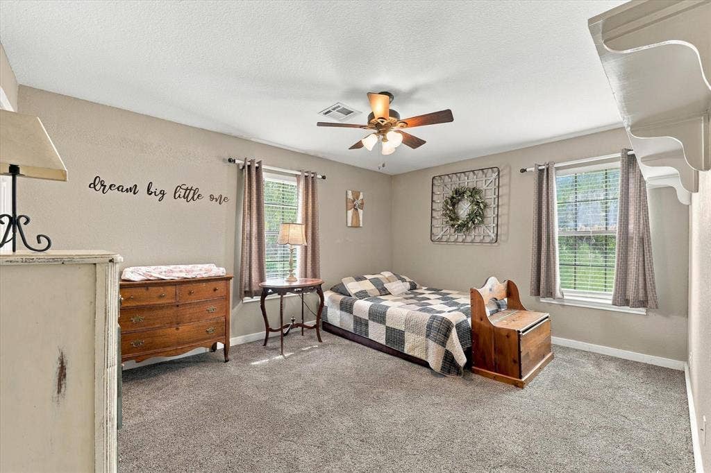 1600 Fox Ridge Road, Lorena, TX 76655 Neutral wall tones, wall-to-wall carpeting, multiple windows, and a central ceiling fan with integrated lighting