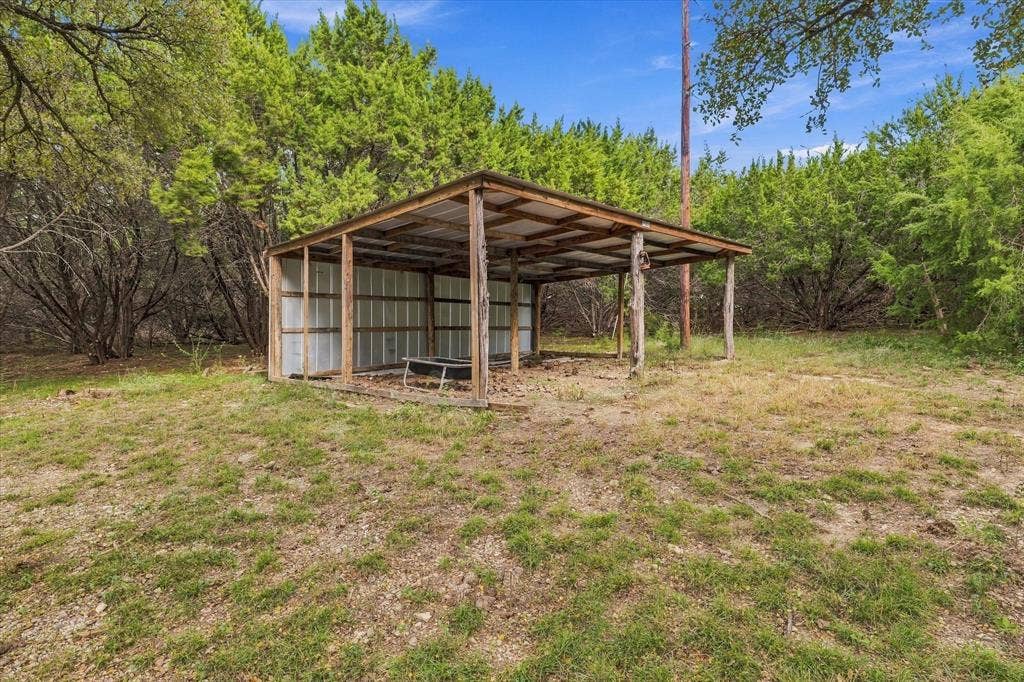 1600 Fox Ridge Road, Lorena, TX 76655 Open-sided metal pole barn featuring a corrugated metal roof and siding, situated on a lot with mature trees