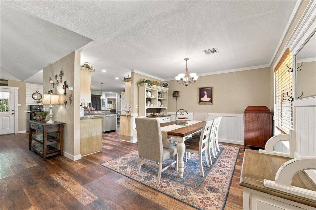 1600 Fox Ridge Road, Lorena, TX 76655 Dining area featuring wood-finish flooring, white wainscoting, and an integrated multi-arm chandelier
