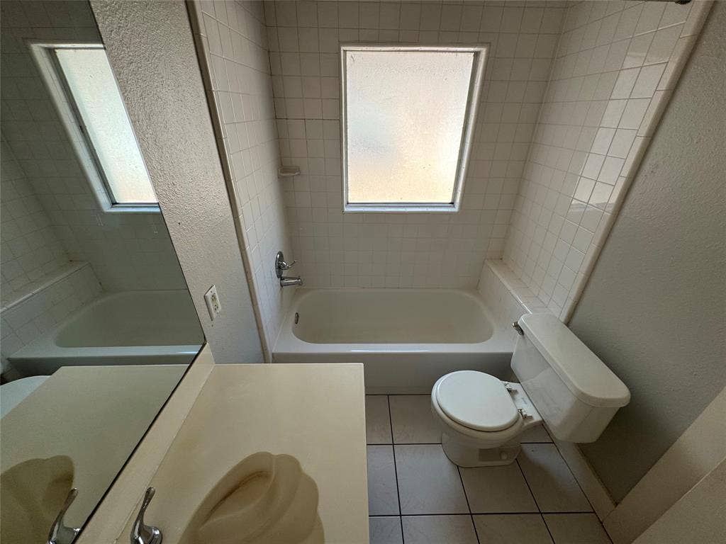 5321 Reiger Avenue, #4, Dallas, TX 75214 Full bathroom with plenty of natural light, toilet, tiled shower / bath combo, and tile patterned floors