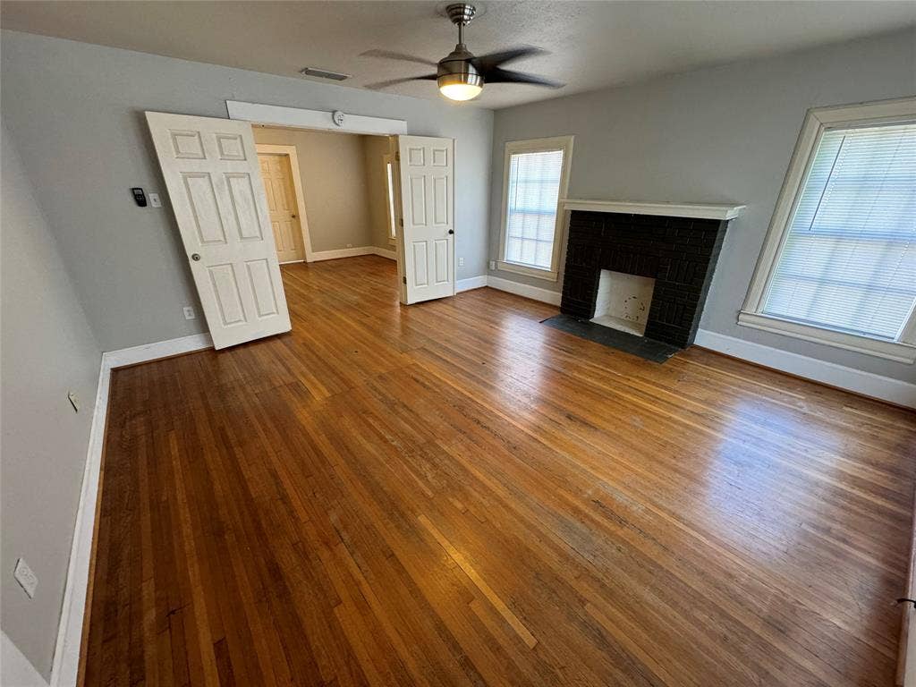 5321 Reiger Avenue, #4, Dallas, TX 75214 Unfurnished living room featuring wood-type flooring, a fireplace, and ceiling fan