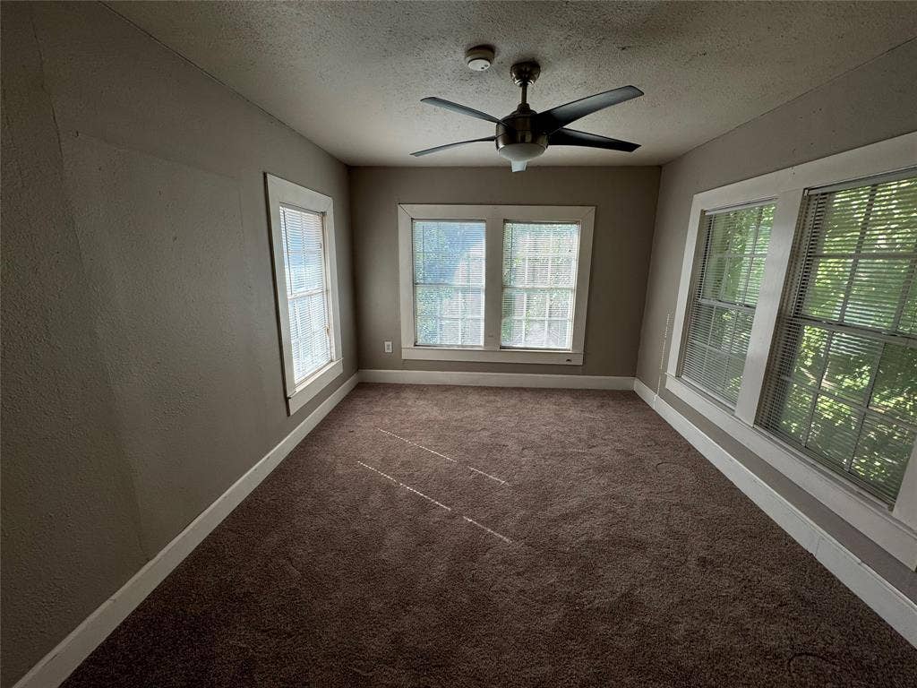 5321 Reiger Avenue, #4, Dallas, TX 75214 Unfurnished room with dark carpet, ceiling fan, and a textured ceiling