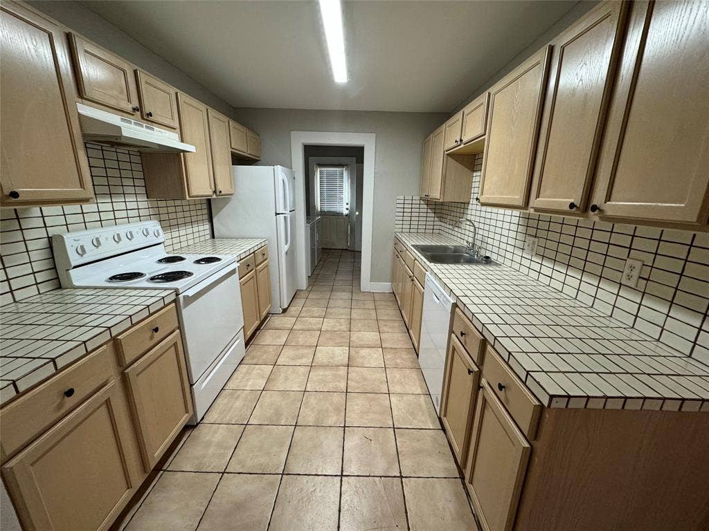 5321 Reiger Avenue, #4, Dallas, TX 75214 Kitchen featuring white appliances, light tile patterned floors, decorative backsplash, and sink