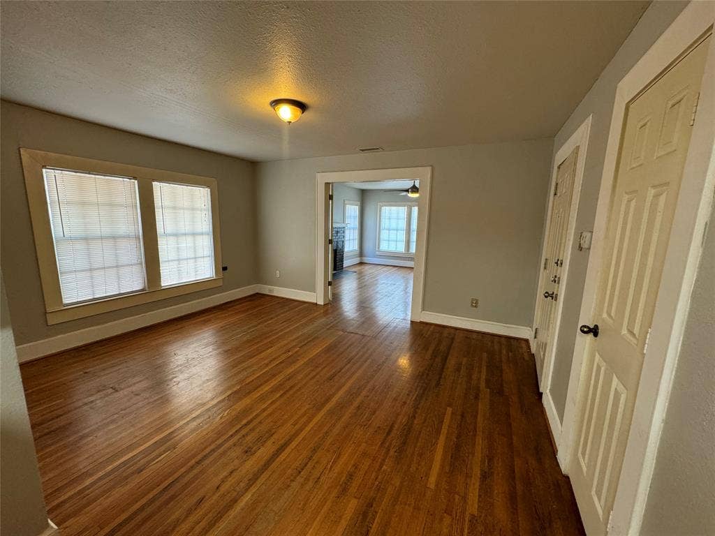 5321 Reiger Avenue, #4, Dallas, TX 75214 Unfurnished room featuring a textured ceiling, a wealth of natural light, ceiling fan, and dark hardwood / wood-style floors