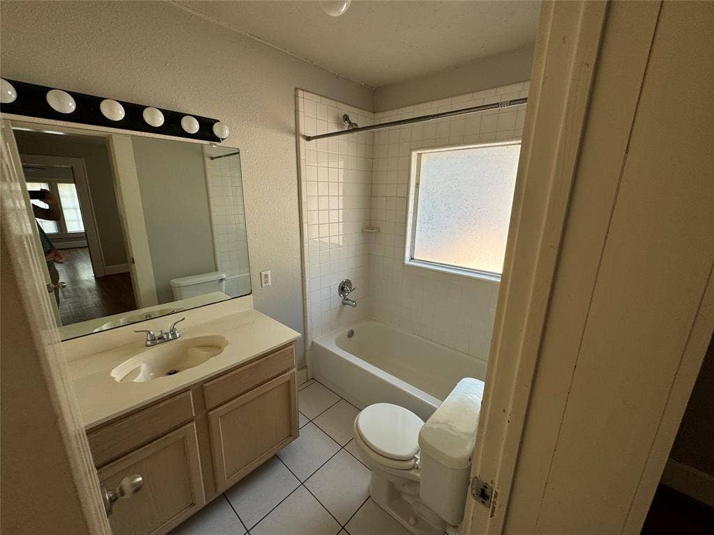 5321 Reiger Avenue, #4, Dallas, TX 75214 Full bathroom featuring vanity, toilet, tiled shower / bath combo, and a healthy amount of sunlight