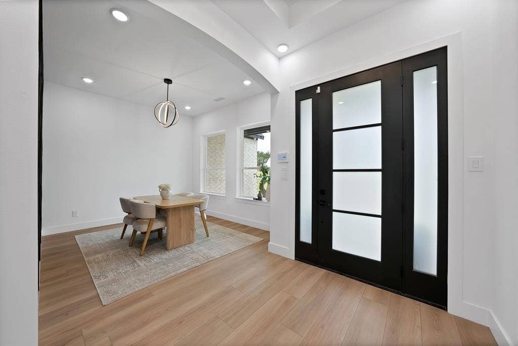 Wide plank wood-finish flooring, recessed lighting, and a modern chandelier