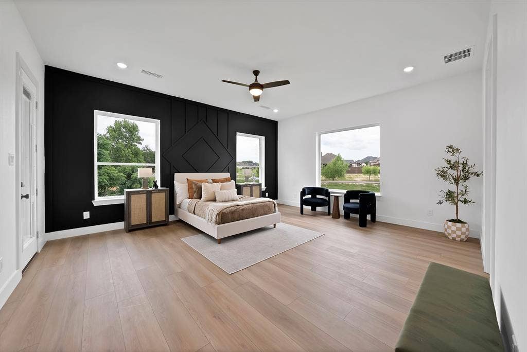 Expansive room featuring light wood-finish flooring, recessed lighting, and a ceiling fan