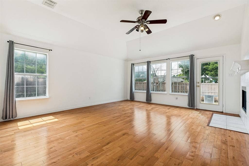 1412 Sleepy Hollow Drive, Allen, TX 75002 Vaulted ceilings, wood-finish flooring, ceiling fan with integrated lighting, multiple large windows, and a glass-paneled door