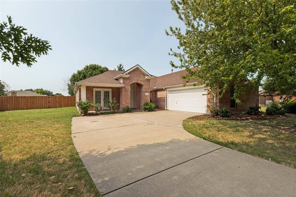 1412 Sleepy Hollow Drive, Allen, TX 75002 Brick exterior with an arched entryway, double-pane windows, and an attached two-car garage