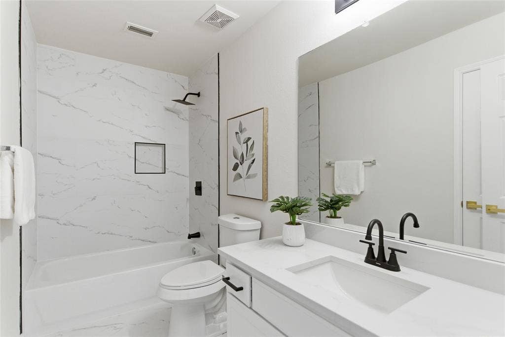 1416 Sunrise Lane, Sachse, TX 75048 White floating vanity with integrated sink, black fixtures, and a large mirror