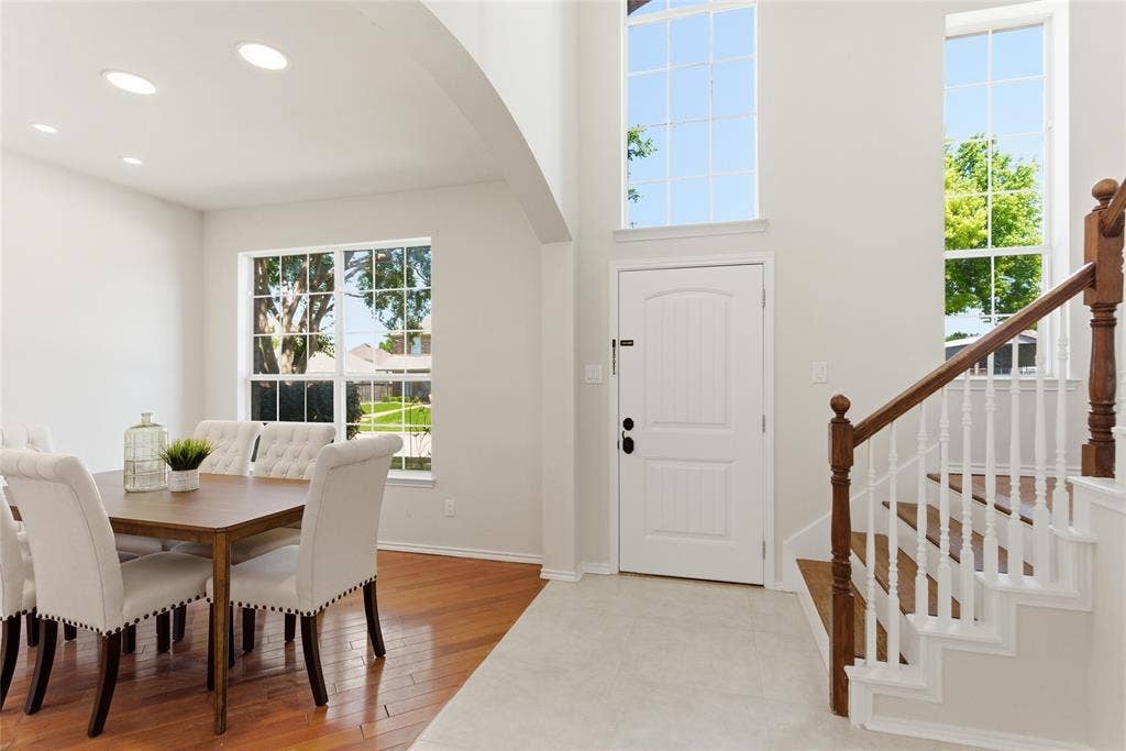 1416 Sunrise Lane, Sachse, TX 75048 Two-story foyer with high ceilings, large windows, and a hardwood staircase with white risers and balusters