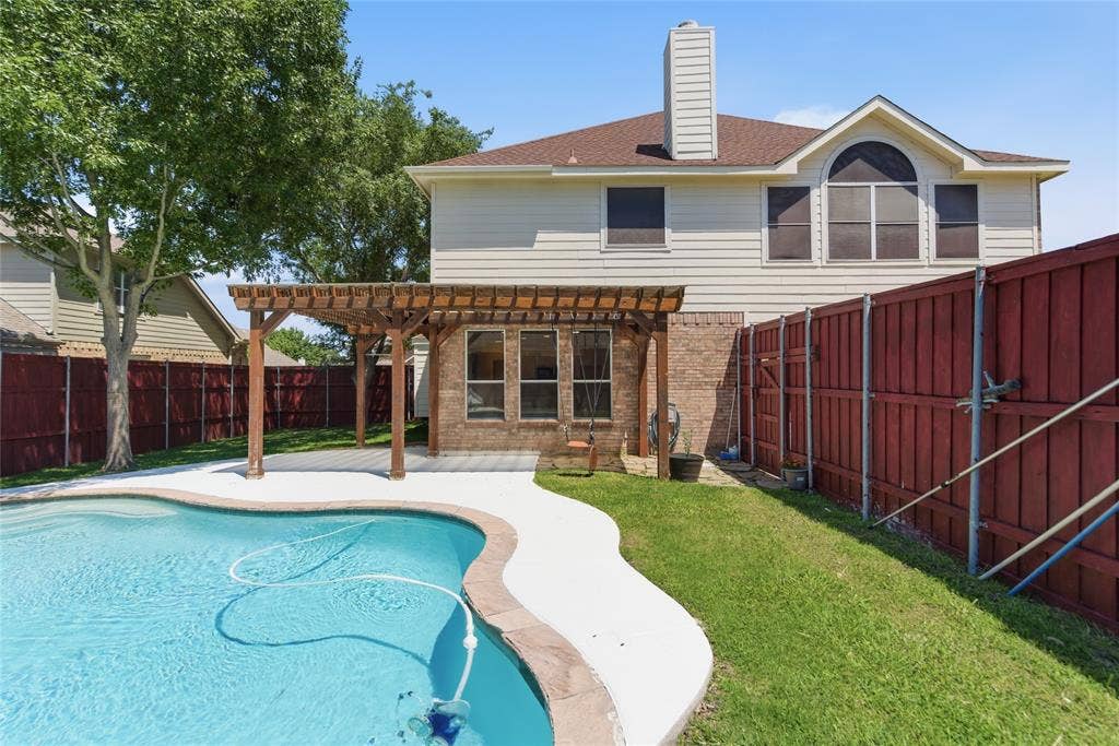 1416 Sunrise Lane, Sachse, TX 75048 In-ground swimming pool with a surrounding concrete deck, wood pergola, and brick exterior accents