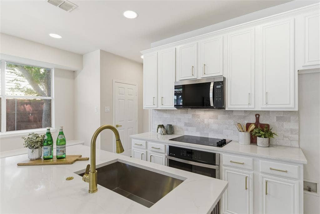 1416 Sunrise Lane, Sachse, TX 75048 Kitchen featuring white cabinetry, a gold-tone gooseneck faucet, an undermount sink, recessed lighting, and a window