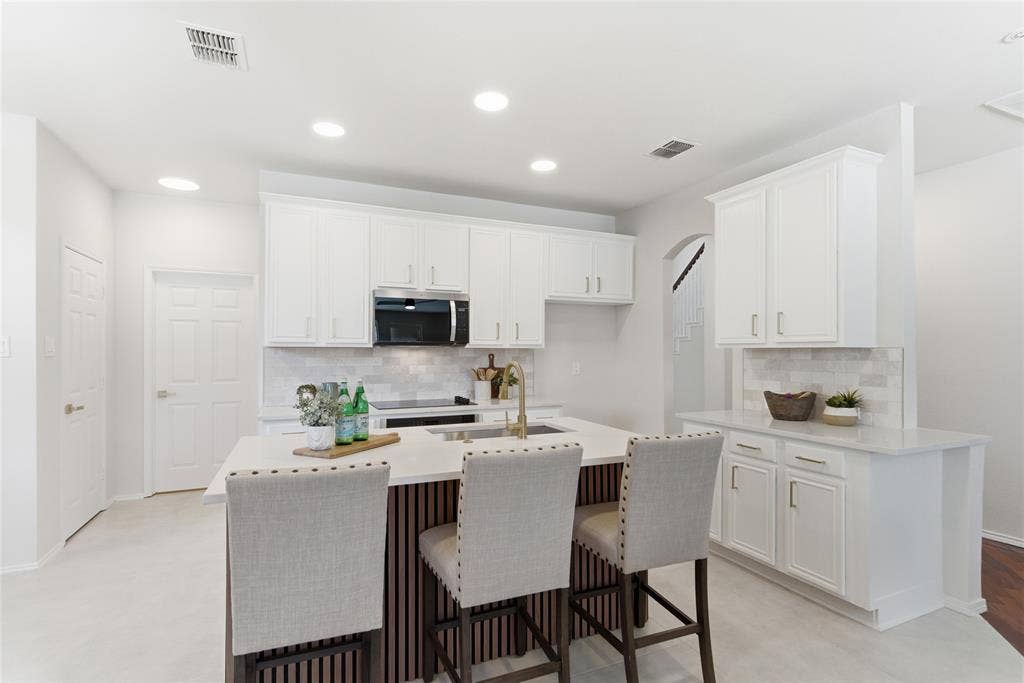 1416 Sunrise Lane, Sachse, TX 75048 Kitchen featuring white cabinetry, a central island with a light-toned countertop, a tile backsplash, and recessed lighting