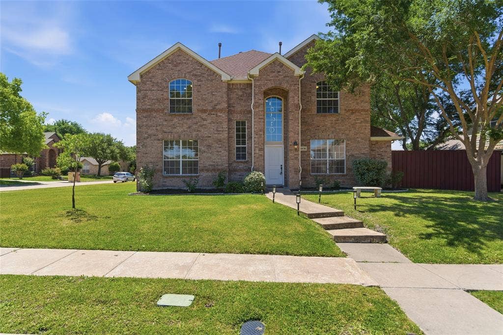 1416 Sunrise Lane, Sachse, TX 75048 Brick facade, multi-pane windows, arched entry window, stepped walkway, and mature trees