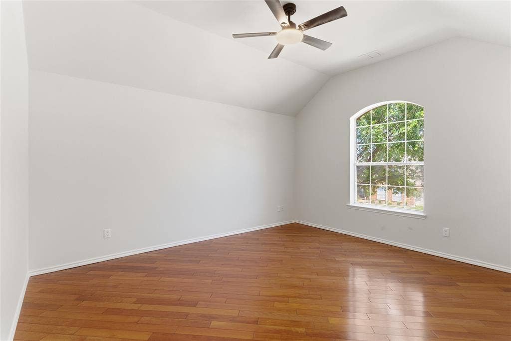 1416 Sunrise Lane, Sachse, TX 75048 Vaulted ceiling with a ceiling fan light fixture, wood-finish flooring, and an arched window