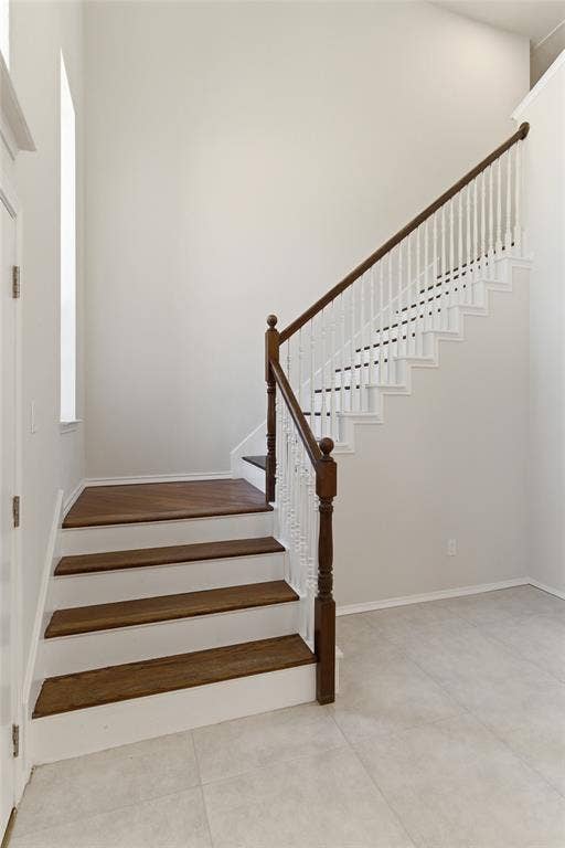 1416 Sunrise Lane, Sachse, TX 75048 Staircase featuring wood-finish treads, white risers, and a classic wood balustrade