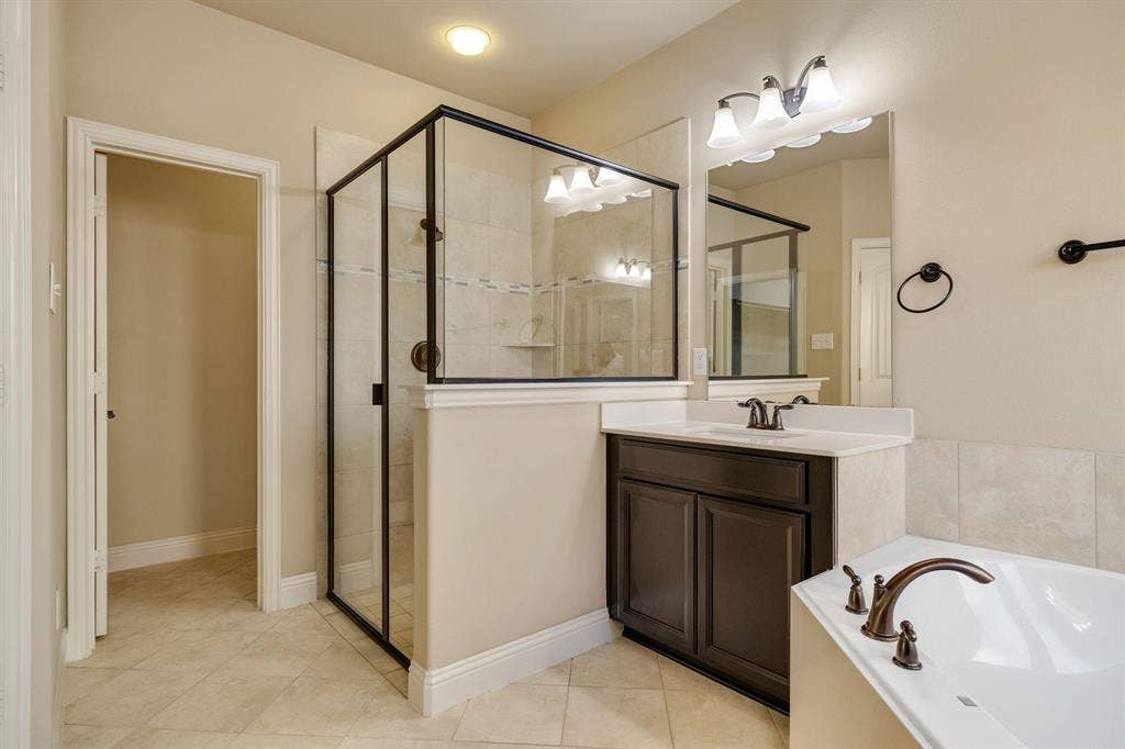 1049 Mesa Crest Drive, Fort Worth, TX 76052 Tiled flooring, dark wood-finish vanity with countertop, frameless mirror, and a walk-in shower with glass enclosure