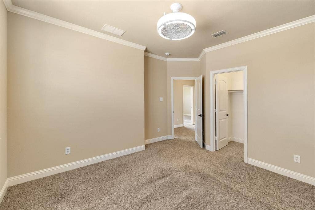1049 Mesa Crest Drive, Fort Worth, TX 76052 Neutral-toned carpeting with white baseboards and crown molding and huge walk in closet